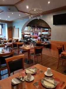 滨湖采尔Dahoam by Sarina - Rooms & Suites的一间带木桌椅的餐厅和一间酒吧