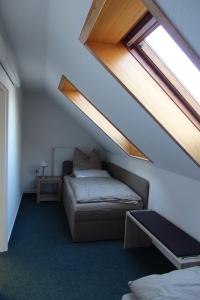 赖因斯贝格Ferienwohnung Rheinsberg的阁楼间 - 带床和窗户