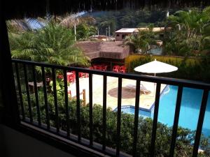 博西坎加RC Sol de Boiçucanga - Suite的设有一个享有泳池美景的阳台。
