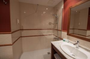 萨拉戈萨东方酒店的带淋浴、盥洗盆和镜子的浴室