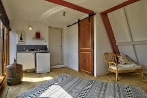 梅登Rooftop studio near Amsterdam Castle (Muiden)的一间卧室配有一张床和一把椅子,一间厨房