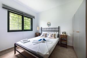 克里皮吉#Luxlikehome - Kriopigi Pines by the Sea的一间卧室配有一张带白色床单的床和一扇窗户。