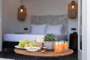 卡马利Aegean Gem的一张桌子,床上放着一碗水果和饮料
