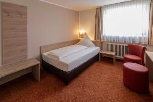 施奈赫普费弗堡酒店的配有一张床和一把椅子的酒店客房