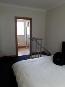 赖德The Grove, Grove Road Ryde Po333lh的卧室配有白色的床和楼梯。