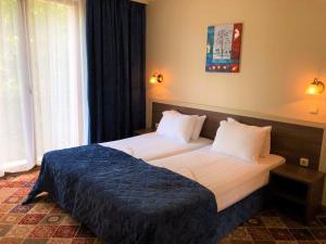 旧扎戈拉拉罗卡酒店的一间卧室配有一张带蓝色毯子的大床