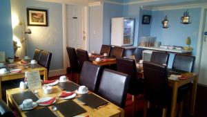 奥本马里敦之家旅馆的用餐室配有木桌和椅子