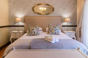 奥茨胡恩伯尔路达农庄及小屋酒店的一间卧室配有一张大床、两盏灯和一面镜子