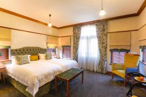 斯泰伦博斯恩德拉奇酒店的酒店客房带一张大床和一把椅子