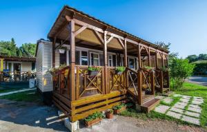 普拉Camping Media Mobile Homes in Brioni Sunny Camping的一座小房子,上面有鲜花门廊