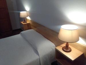 马希库AL Moniz的一间卧室配有一张床和一张带台灯的桌子