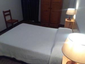 马希库AL Moniz的卧室配有一张白色大床和一把椅子