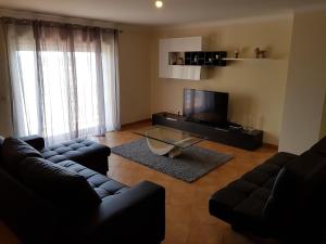 波尔蒂芒Encosta da Marina Residence的客厅配有两张沙发和一台电视