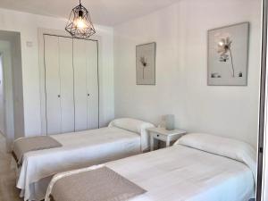 马贝拉Apartamento Guadalmina - Golf & Playa - Marbella的一间医院间,配有两张床和镜子
