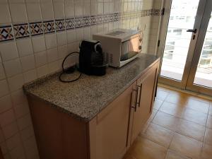 波尔蒂芒Encosta da Marina Residence的厨房的台面上有一个微波炉