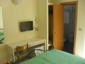 萨米凯莱-迪巴里艾斯贝里阿酒店的客房设有书桌和墙上的电视。