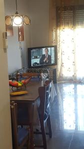 坎波马里诺appartamento Lory的客厅配有桌子和电视机,上面有男人