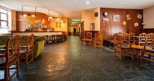 维耶拉西皮客酒店的一间带木桌椅的餐厅和一间酒吧