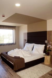 AjkaHotel Fitromax Ajka的卧室配有带白色枕头的大床