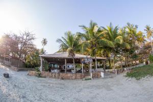 巴雷克萨巴Pris Hotel的海滩上的餐厅,以棕榈树为背景
