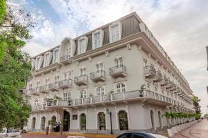 巴拿马城Central Hotel Panama Casco Viejo的白色的建筑,在街上设有阳台