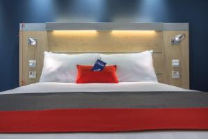凯特林Holiday Inn Express Kettering, an IHG Hotel的一张大床,上面有两个红色的枕头