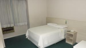 库里提巴Rede Andrade San Martin的卧室配有白色的床和窗户。