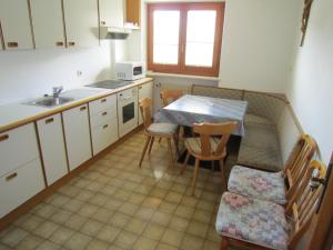 马莱斯韦诺斯塔Aparthotel Garni Haus Hubertus的厨房配有桌椅和水槽。