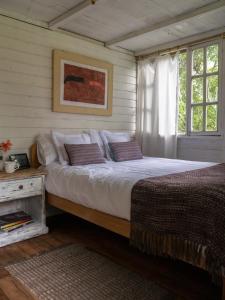 PeñaherreraPacheco Farmhouse - Intag Valley的一间卧室设有一张大床和一个窗户。