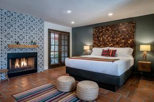 棕榈泉Santiago Resort - Palm Springs Premier Gay Men’s Resort的一间卧室配有一张床和一个壁炉