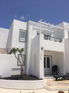 卡门港Panelolanza的前面有棕榈树的白色房子