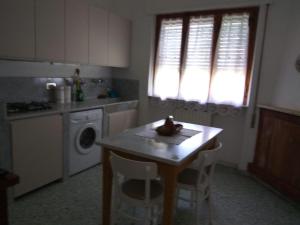 彼得拉桑塔Casa del Nonno的厨房配有桌子和洗衣机。