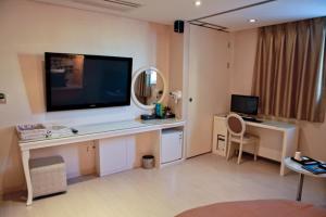 首尔钻石酒店的客房设有一张桌子,墙上挂着一台大电视
