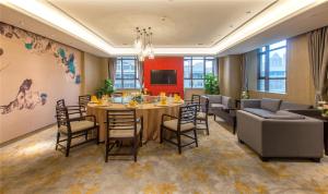 武汉武汉洪广大酒店的一间带桌椅和沙发的用餐室