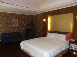 新竹向日葵汽车旅馆 的卧室配有白色的床和蓝色椅子