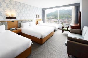 首尔美利来酒店首尔明洞.的酒店客房,设有三张床和一张沙发