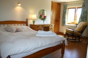 普雷斯蒂克Garden Cottage的一间卧室配有一张床、一把椅子和镜子