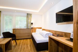 伊施格尔Hotel Garni Siegele - Silvretta Card Premium Betrieb的配有一张床和一张书桌的酒店客房