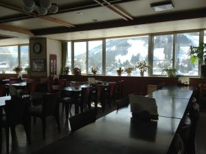 白马村哈珀坎旅馆的用餐室设有桌椅和窗户。