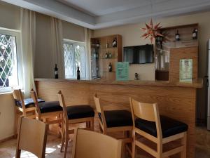 伯利恒塔利莎库米旅馆的餐厅设有酒吧,配有木桌和椅子