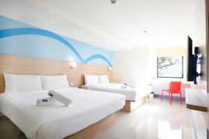 马尼拉Hop Inn Hotel Alabang Manila的酒店客房配有两张床和一张书桌