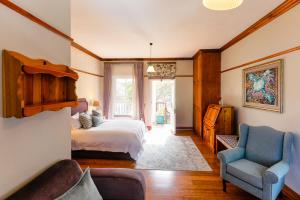 斯泰伦博斯恩德拉奇酒店的一间卧室配有一张床、一张沙发和一把椅子