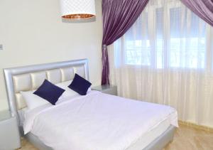 纳祖尔The happy lounge的卧室配有白色床、蓝色枕头和窗户
