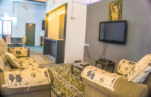 怡保Ipoh Boutique Stay的客厅配有2张沙发和1台平面电视