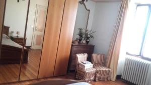Casale Corte CerroB&B Al Mutpron的一间卧室配有镜子、椅子和一张床