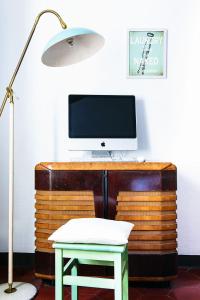 切尔诺比奥Little Garden House的一张带电脑显示器的桌子、一把椅子和一盏灯