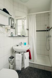 利斯塔尔Bienenberg - Das Genusshotel im Grünen - Liestal的白色的浴室设有水槽和淋浴。