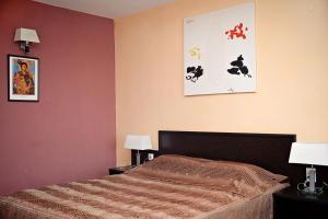Vratsa佐拉家庭艺术酒店的一间卧室配有一张带两盏灯和两张照片的床。
