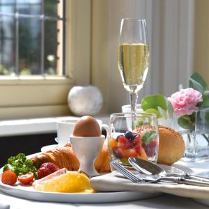 哈瑟尔特萨派瑞斯魅力别墅酒店的一张桌子,上面放着一盘食物和一杯香槟