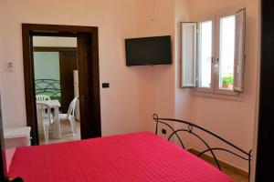 科佩尔蒂诺Iconella camere vacanze的一间卧室配有红色的床和电视